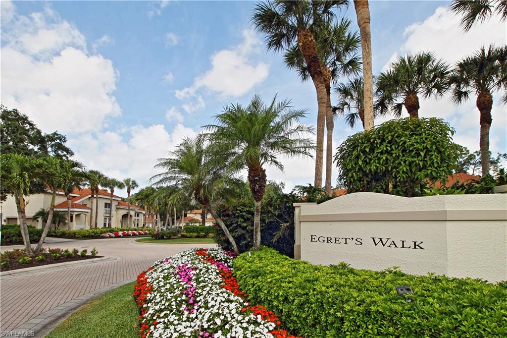 970 Egrets Run, Unit 201 Naples, FL 34108 - Photo 25 of 50 a front view of multi story residential apartment building with yard and sign board