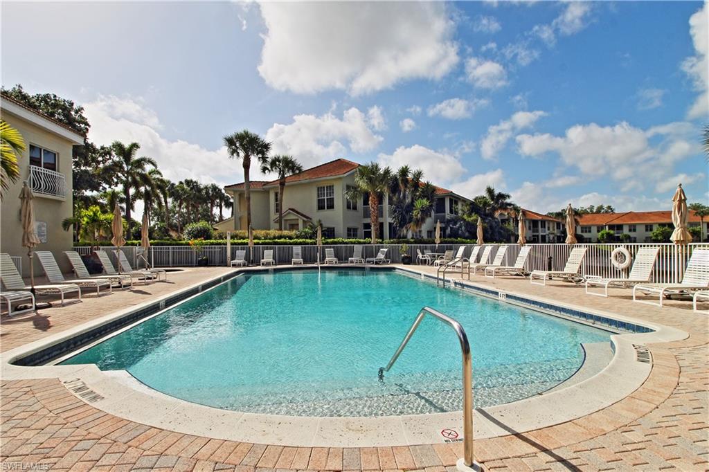970 Egrets Run, Unit 201 Naples, FL 34108 - Photo 26 of 50 a view of a swimming pool with a lounge chairs