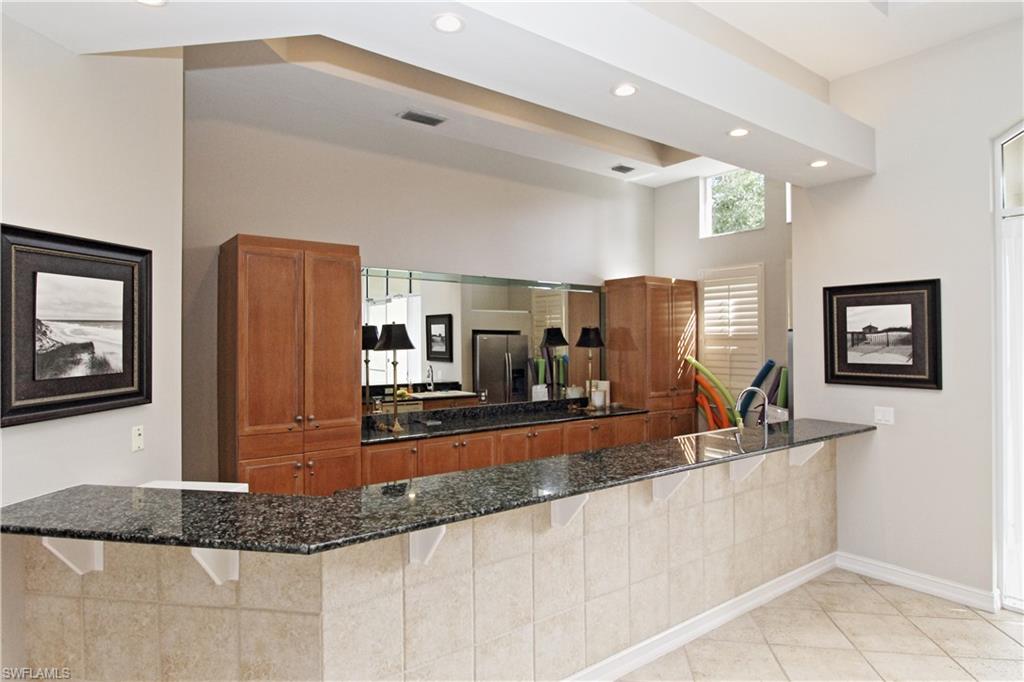 970 Egrets Run, Unit 201 Naples, FL 34108 - Photo 34 of 50 a large kitchen with granite countertop a sink a counter top space appliances and cabinets