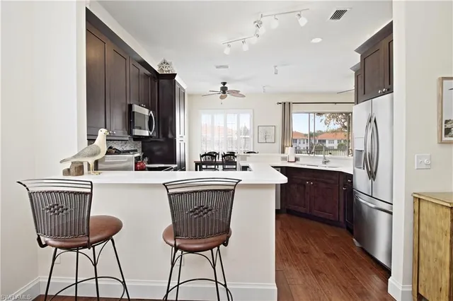 a kitchen with a sink a stove cabinets and wooden floor