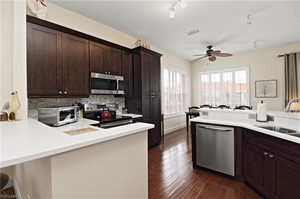 970 Egrets Run, Unit 201 Naples, FL 34108 - Photo 7 of 50 a kitchen with a sink a stove cabinets and wooden floor