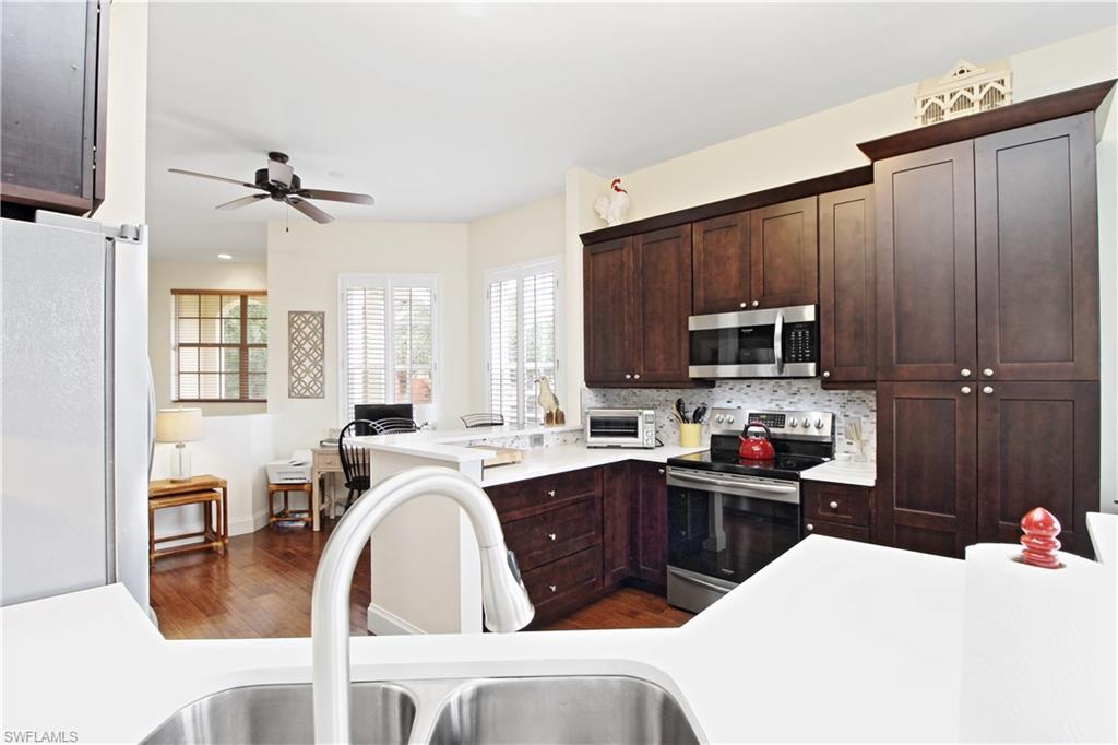 970 Egrets Run, Unit 201 Naples, FL 34108 - Photo 8 of 50 a kitchen with sink a microwave and cabinets