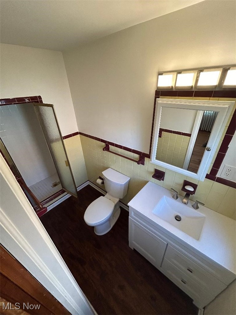 1130 Carver Road Cleveland, OH 44112 - Photo 20 of 32 Master Bathroom featuring toilet, vanity, tile walls, and hardwood / wood-style floors