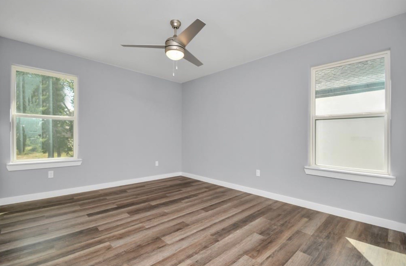 5709 Breland Street, Unit A Houston, TX 77016 - Photo 15 of 26 an empty room with wooden floor and windows