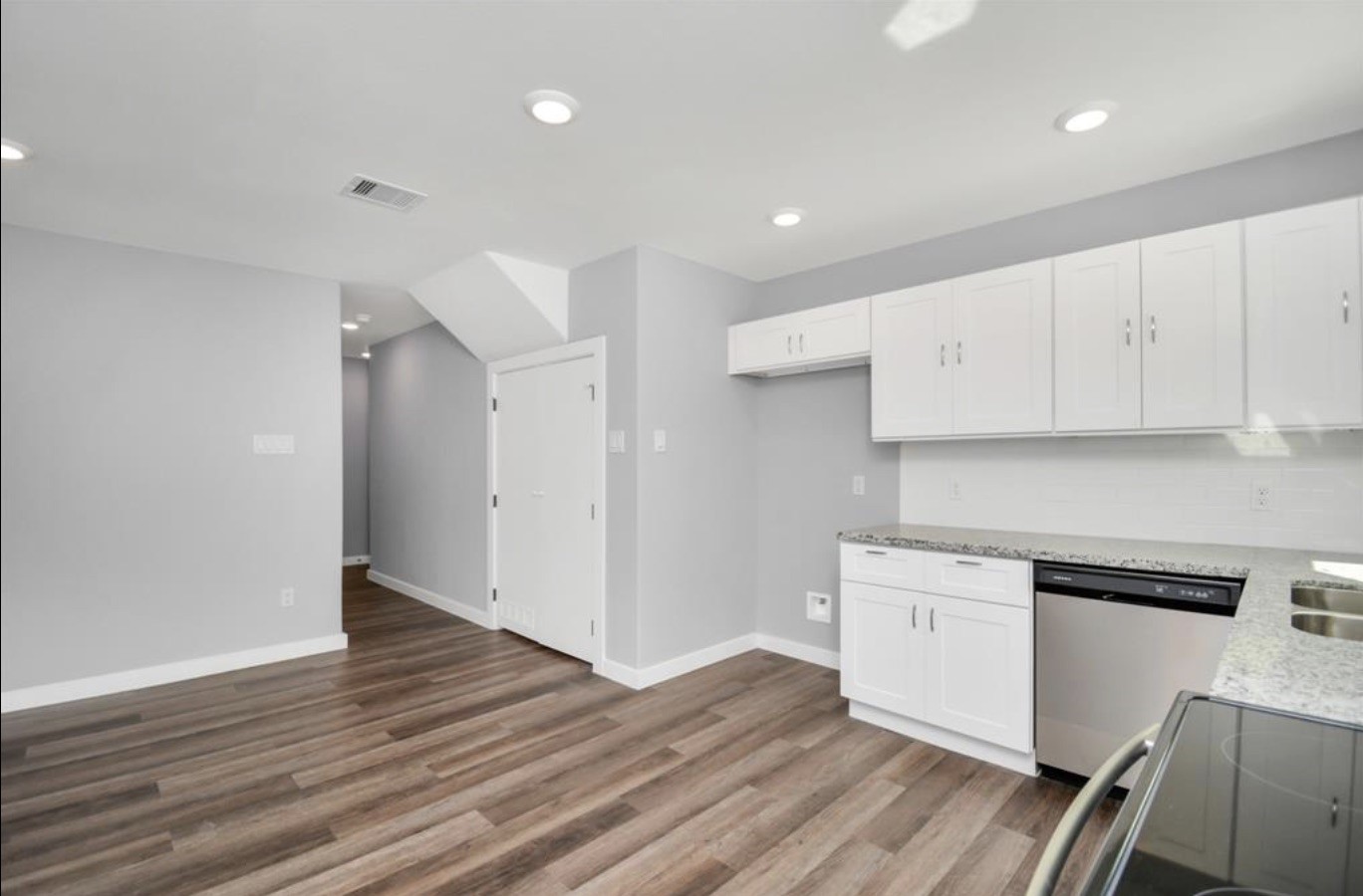 5709 Breland Street, Unit A Houston, TX 77016 - Photo 7 of 26 a kitchen with wooden floors and white cabinets