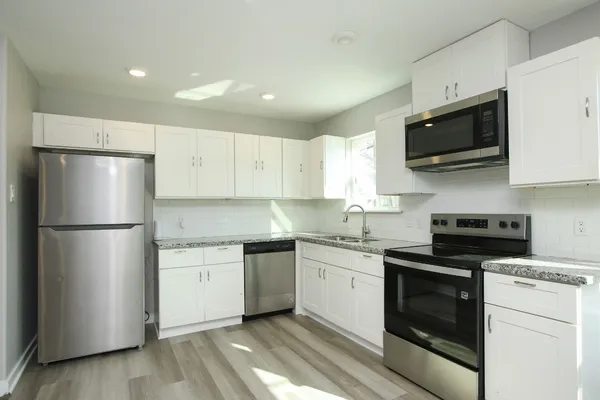 a kitchen with stainless steel appliances a stove microwave and sink