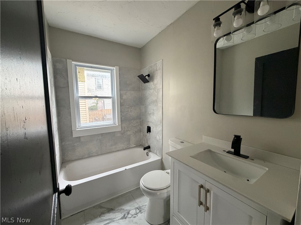 15317 Shiloh Road Cleveland, OH 44110 - Photo 8 of 29 Bathroom featuring a white vanity with brushed nickel hardware, a black-framed mirror, and a three-light vanity fixture