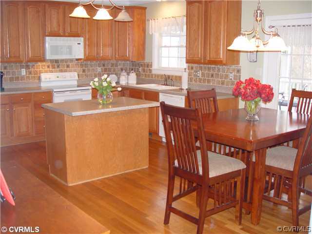 1307 Goswick Ridge Road Midlothian, VA 23114 - Photo 3 of 12 a kitchen with stainless steel appliances kitchen island granite countertop a dining table chairs and a refrigerator