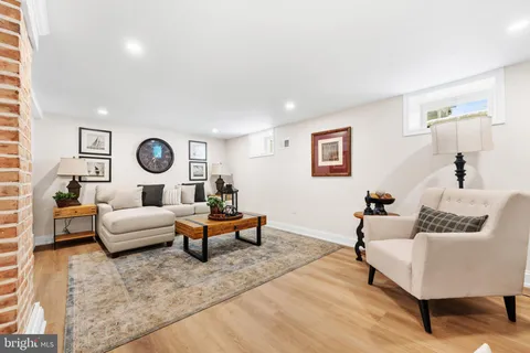a living room with furniture a flat screen tv and kitchen view