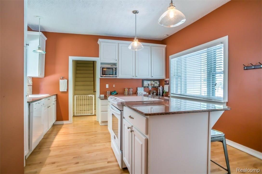 722 North State Street Howell, MI 48843 - Photo 13 of 27 Granite counters and a large island with snack bar