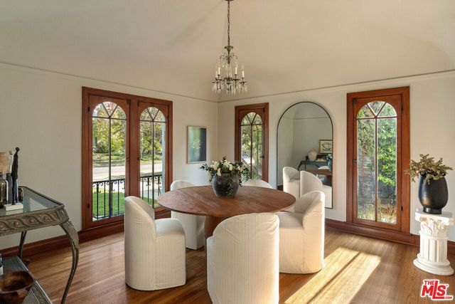 a dining room with furniture potted plants and wooden floor