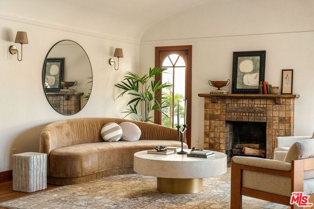 a living room with fireplace furniture and a large window