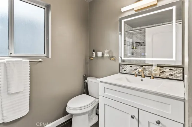 a bathroom with a sink a toilet and mirror