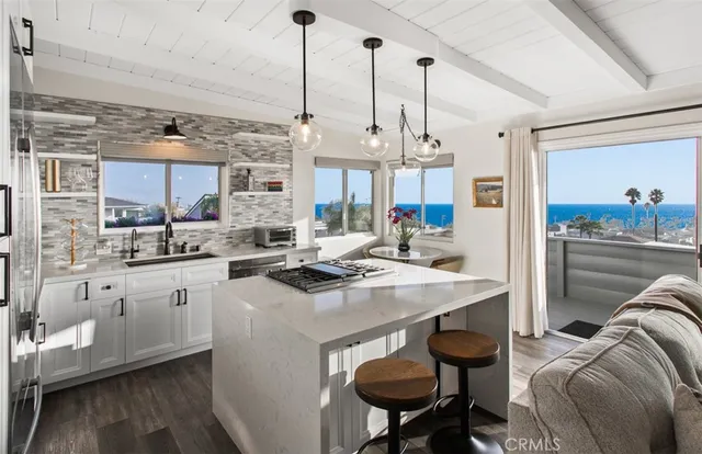a open kitchen with stainless steel appliances granite countertop a sink a stove and a refrigerator