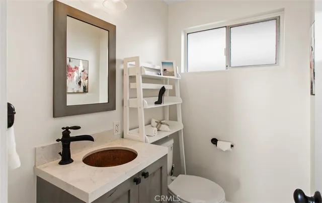 a bathroom with a toilet sink vanity and mirror