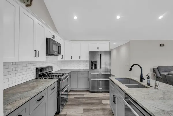 a kitchen with stainless steel appliances granite countertop a sink stove and refrigerator