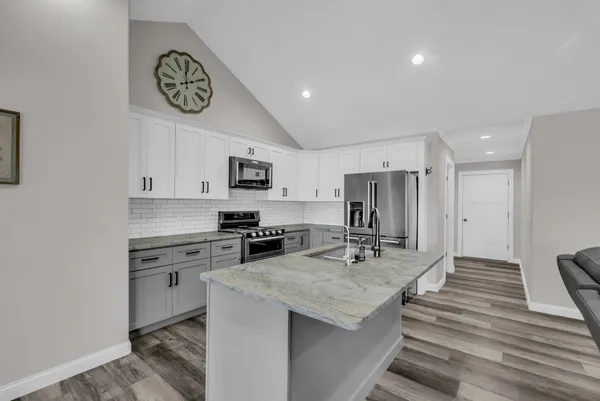 a kitchen with kitchen island a stove sink and cabinets