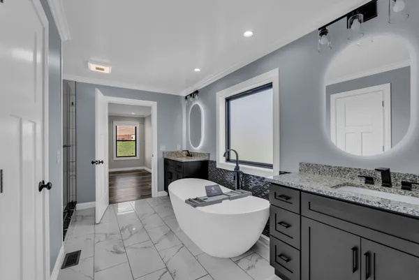 a bathroom with a granite countertop sink mirror and bathtub