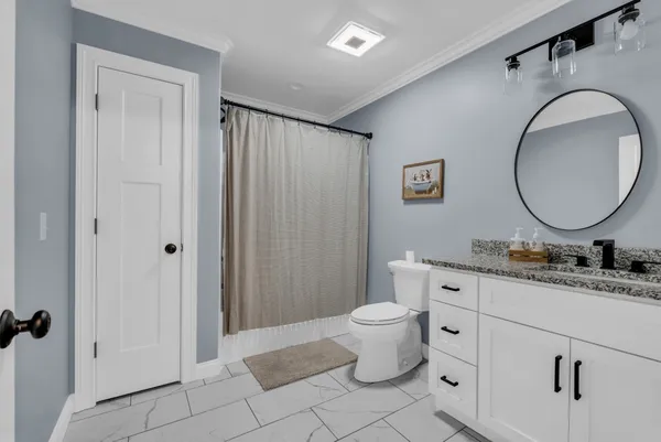 a bathroom with a double vanity sink mirror and toilet