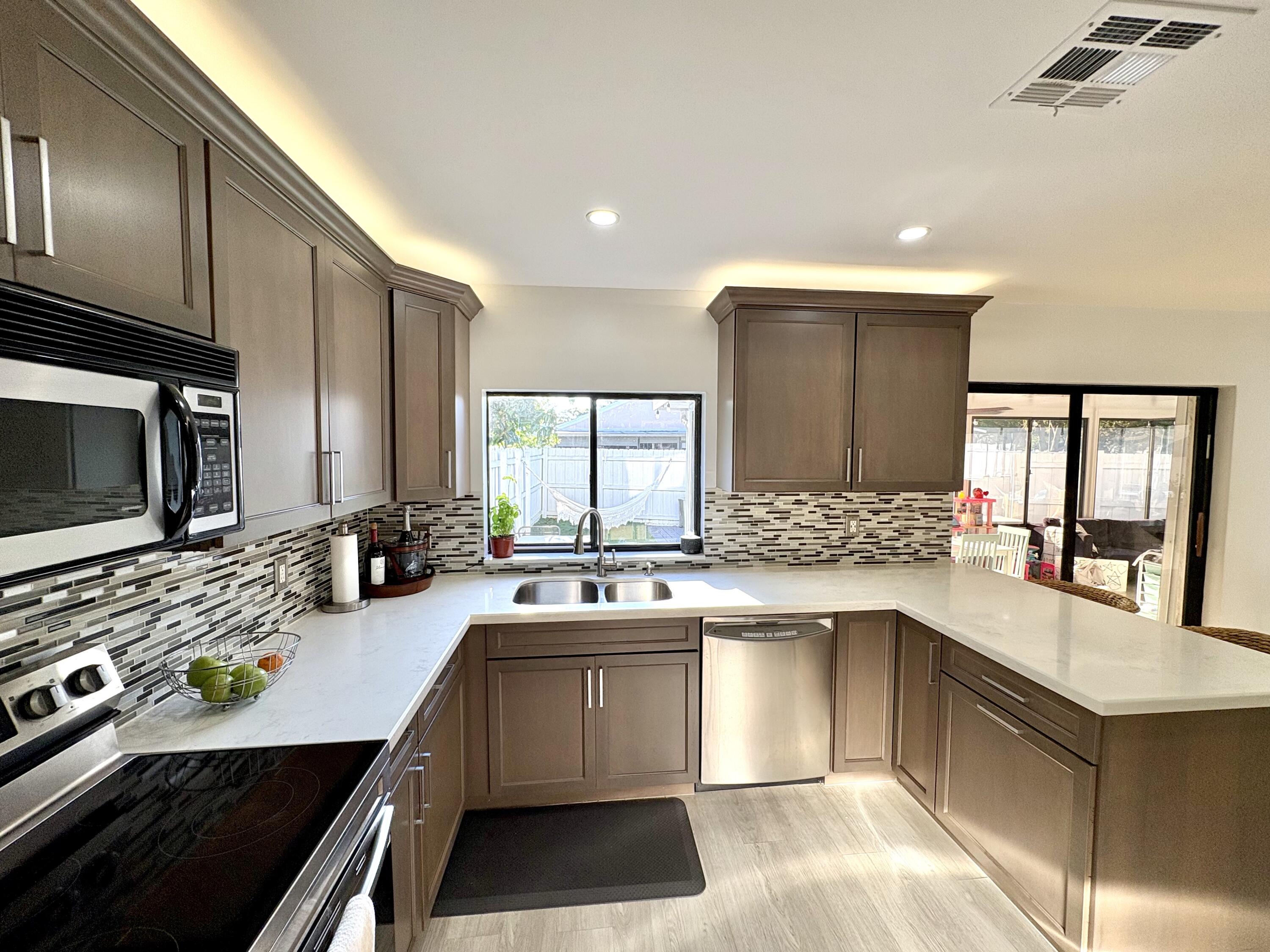 3 Kyle Way Boynton Beach, FL 33426 - Photo 11 of 36 a kitchen with a sink stove and cabinets