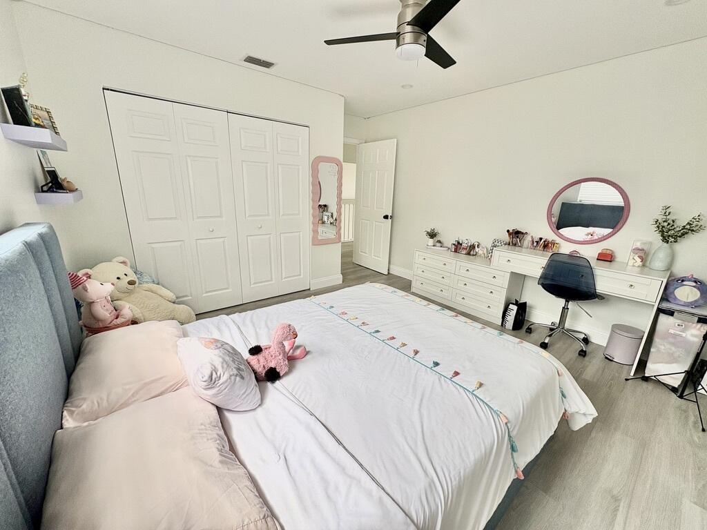 3 Kyle Way Boynton Beach, FL 33426 - Photo 16 of 36 a bedroom with a bed and a chandelier