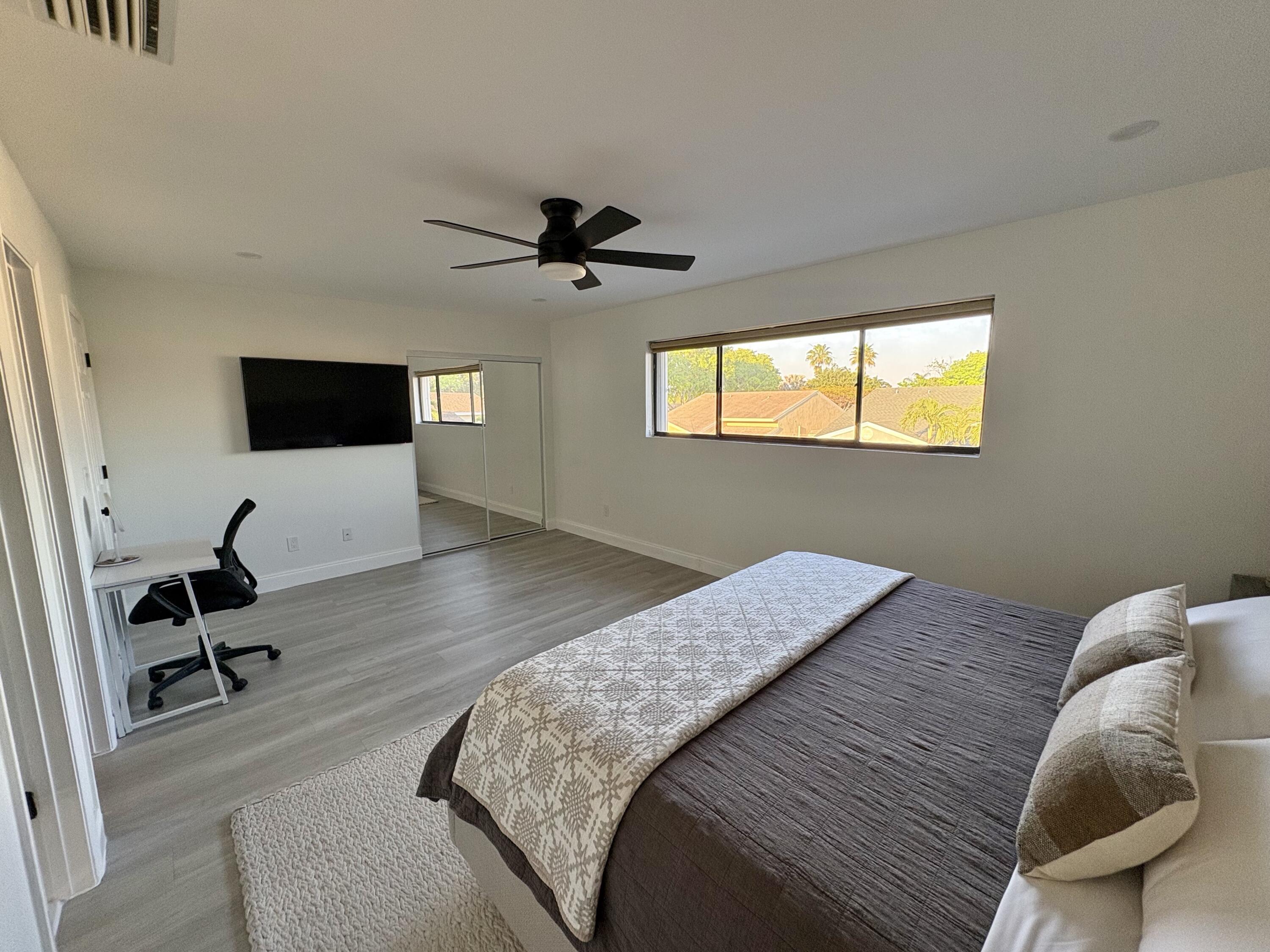 3 Kyle Way Boynton Beach, FL 33426 - Photo 22 of 36 a bedroom with a bed and a flat screen tv