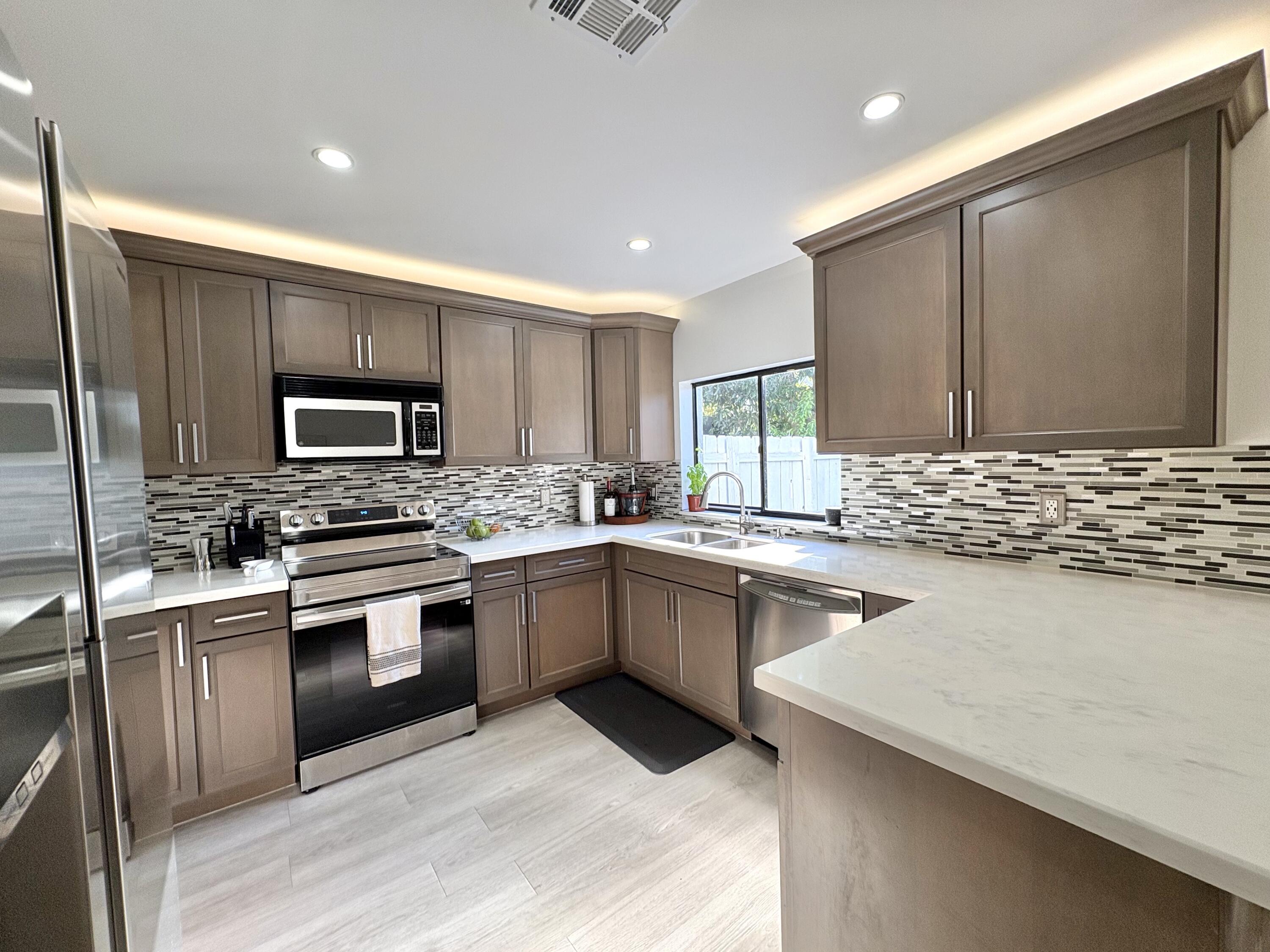 3 Kyle Way Boynton Beach, FL 33426 - Photo 9 of 36 a kitchen with a sink stove and microwave