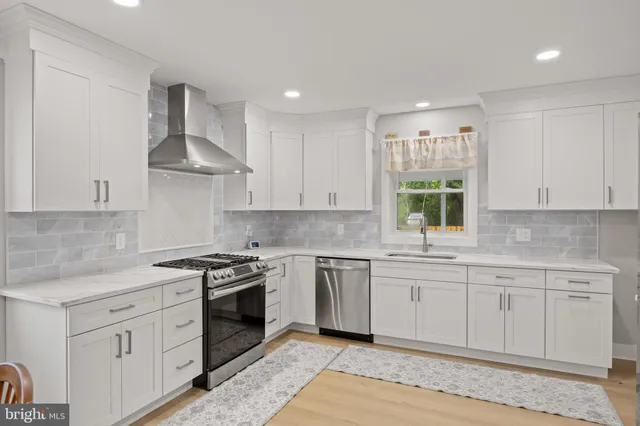 a kitchen with stainless steel appliances granite countertop a sink stove and cabinets