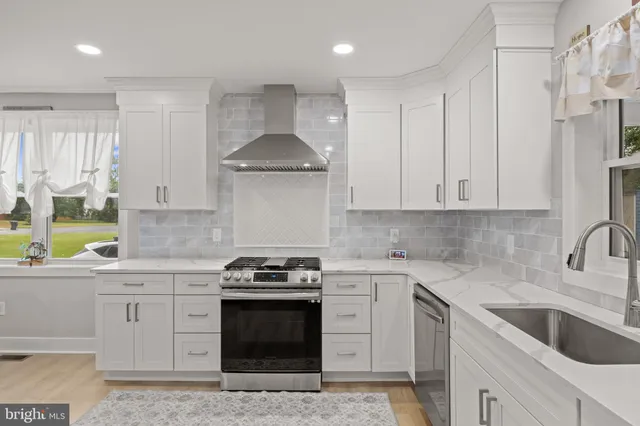 a kitchen with stainless steel appliances granite countertop a sink stove and cabinets