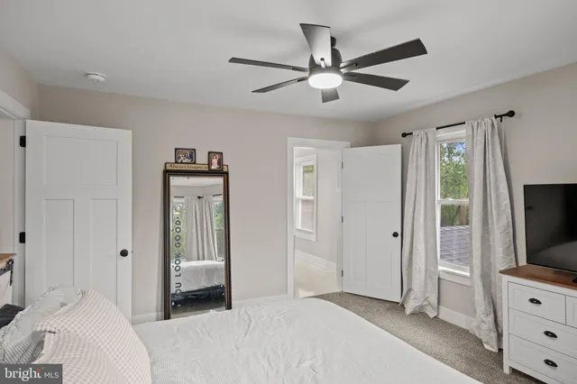 a bedroom with a bed and a flat tv screen on dresser