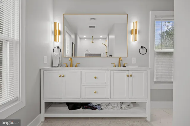 a bathroom with a sink vanity and mirror