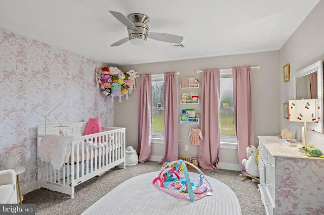 a bedroom with furniture a baby crib and a chandelier