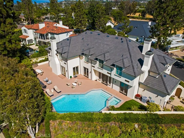 a large white kitchen with a large window a sink and stainless steel appliances