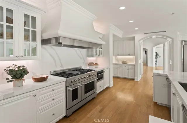 a kitchen with kitchen island granite countertop wooden floors and white cabinets