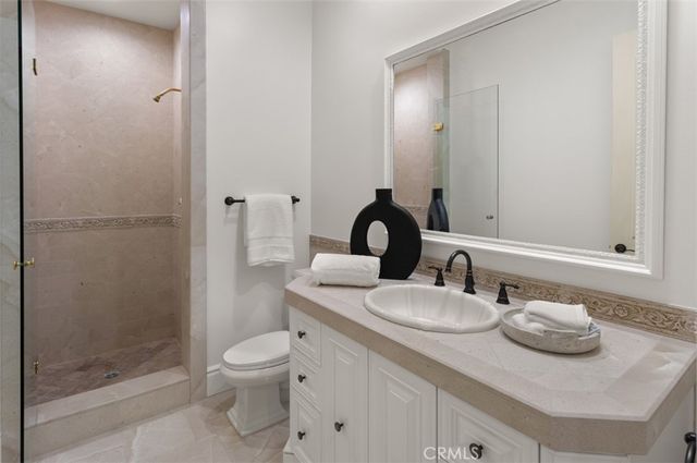 a bathroom with a granite countertop toilet sink and mirror