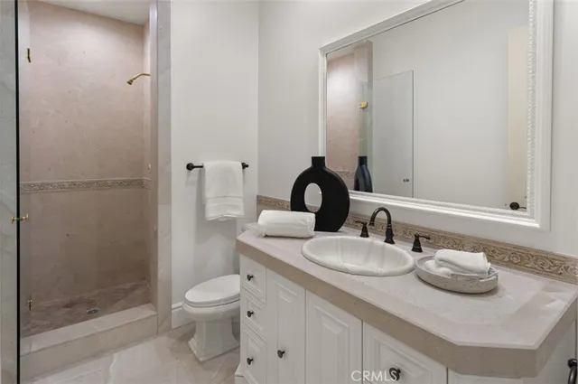 a bathroom with a granite countertop toilet sink and mirror