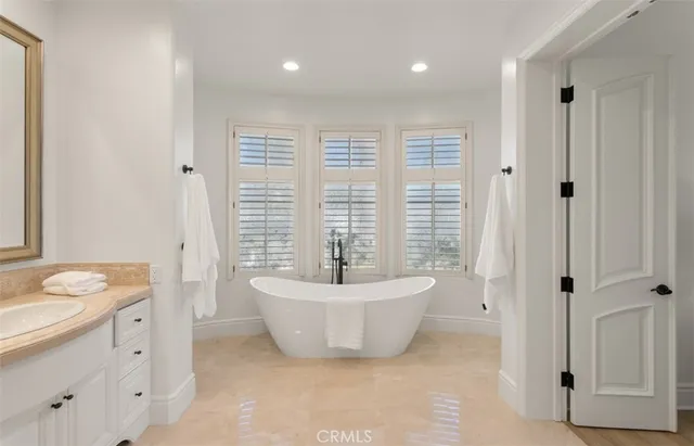 a spacious bathroom with a bathtub sink and mirror