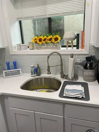 a kitchen with a stove a sink and a wooden floor