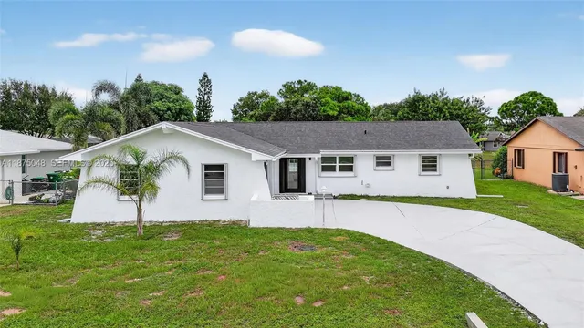 a aerial view of a house next to a big yard and large trees