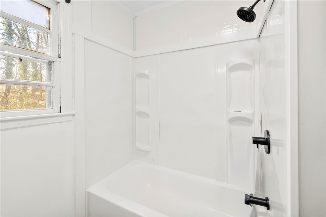 825 Dora Drive Anderson, SC 29624 - Photo 17 of 27 This bathroom features a sleek, modern bathtub with a dark-finished shower head.