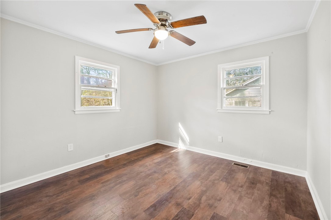 825 Dora Drive Anderson, SC 29624 - Photo 21 of 27 This airy bedroom features abundant natural light and warm wood-look flooring.