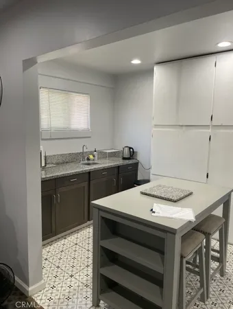 a kitchen with a sink a stove and chairs