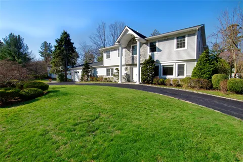 a front view of a house with a yard and trees