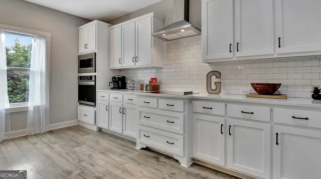 a kitchen with white cabinets and sink