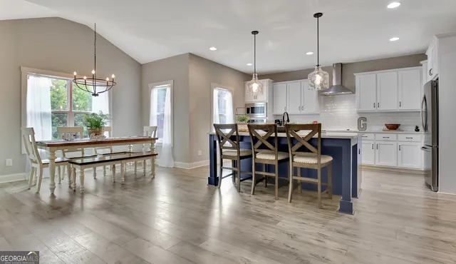 a view of a dining room and livingroom with furniture wooden floor a chandelier
