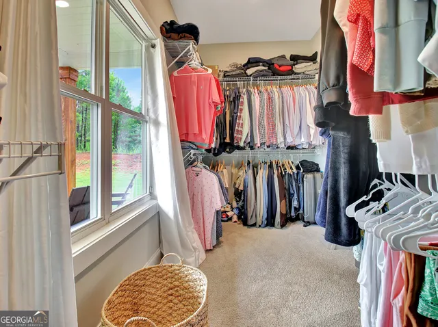 a view of walk in closet with clothes