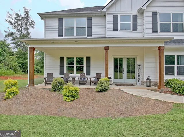 a front view of a house with a yard and outdoor seating