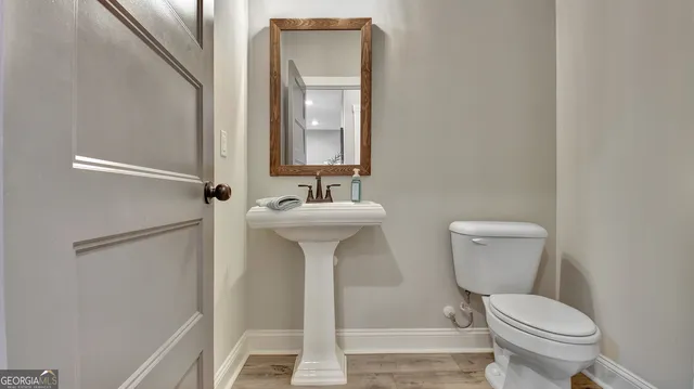 a bathroom with a toilet sink and mirror