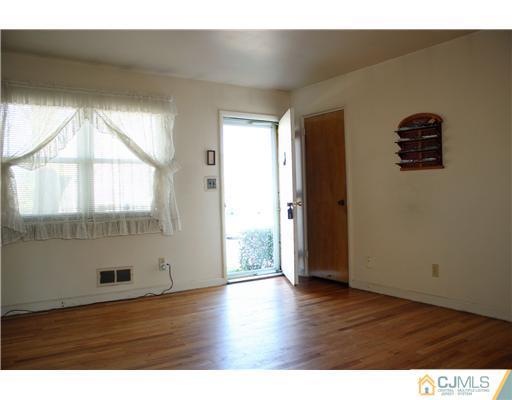 8 Wilshire Road Edison, NJ 08817 - Photo 2 of 25 a view of an empty room with wooden floor and a window