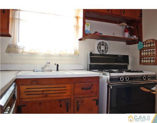 8 Wilshire Road Edison, NJ 08817 - Photo 15 of 25 a kitchen with a stove and a microwave